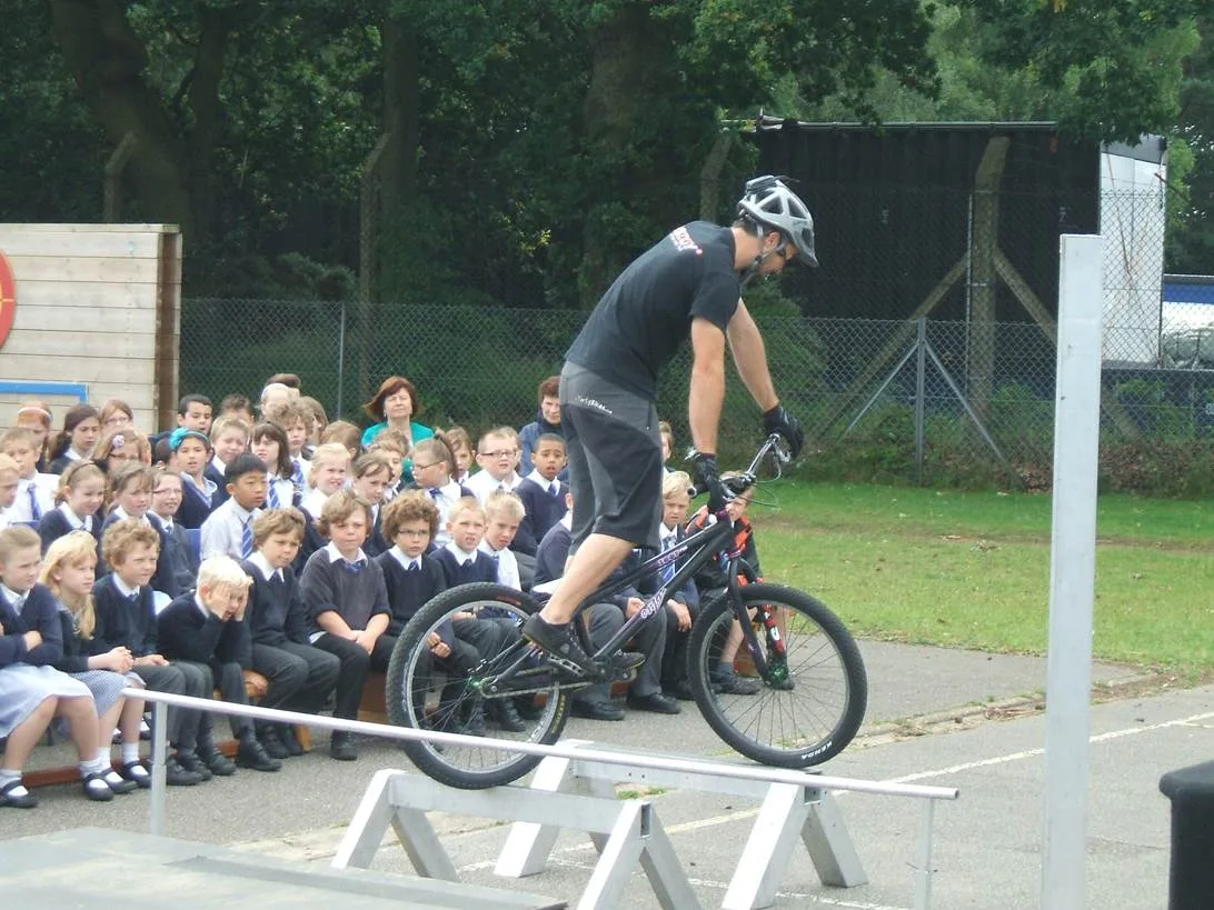 School pupils watching a 3SIXTY bicycle stunt display outdoors
